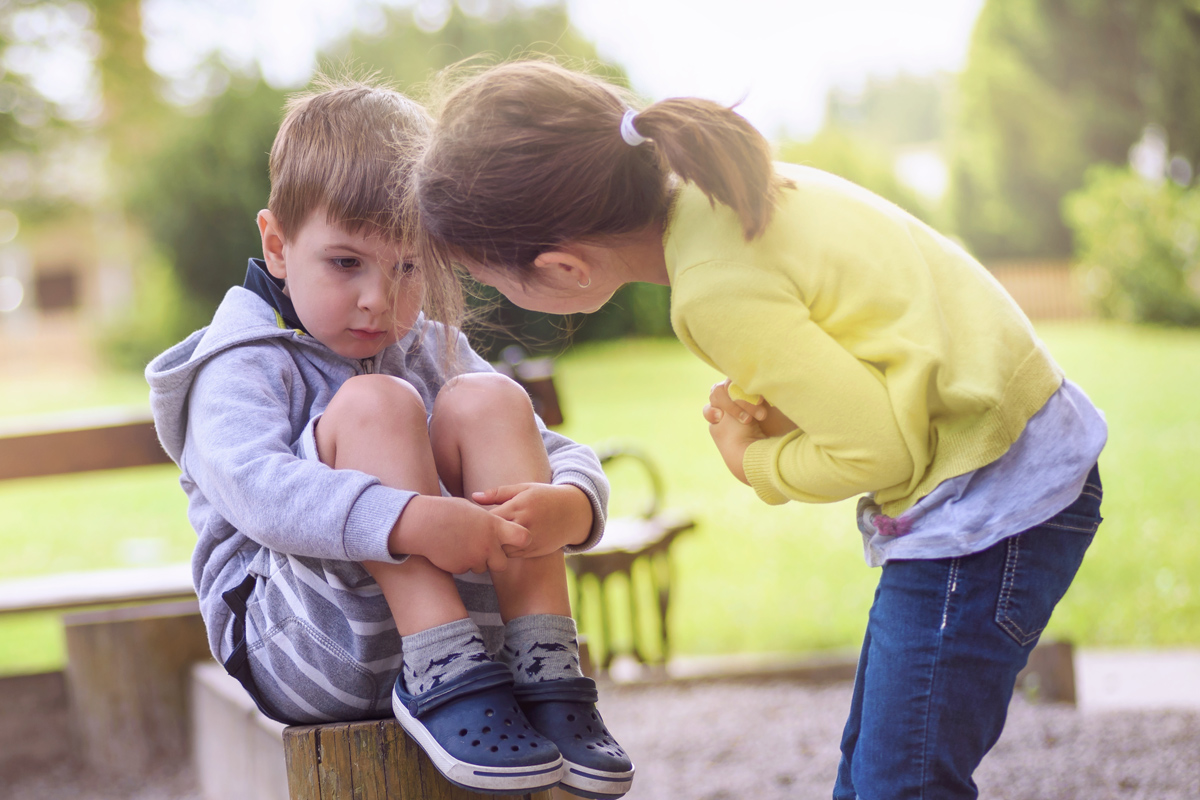 Mädchen tröstet einsamen Jungen Mädchen tröstet einsamen Jungen