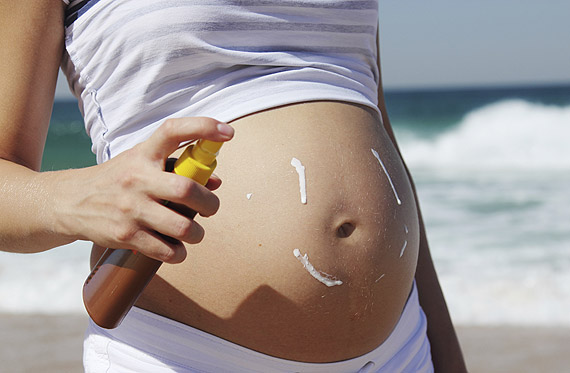 Schwanger im Sommer: Schwangere trägt Sonnencreme auf Schwanger im Sommer: Schwangere trägt Sonnencreme auf