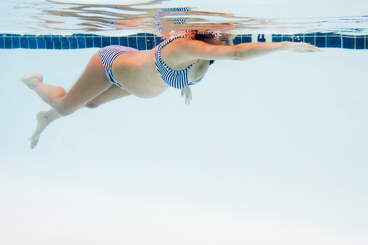 Schwangere Frau schwimmt im Wasser Schwangere Frau schwimmt im Wasser