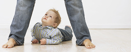 Baby unter Beinen von Elternteil