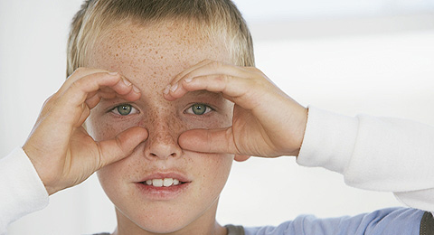Junge bildet Brille mit seinen Händen