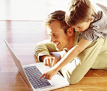 Sohn mit Vater vor dem Computer