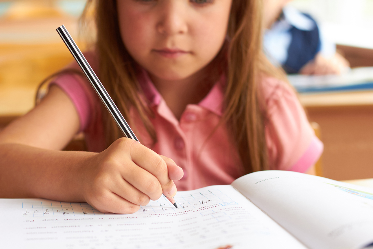 Junges Mädchen schreibt in der Schule