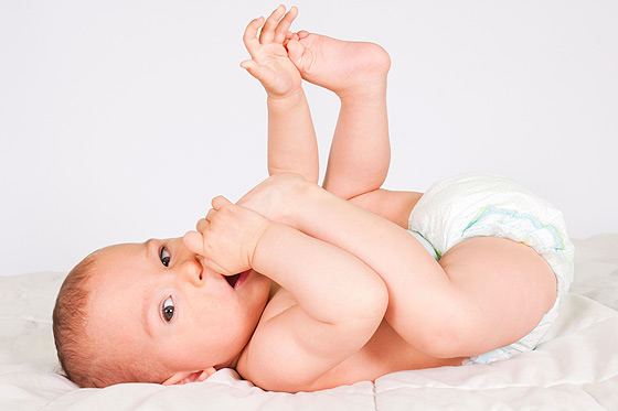 Baby mit fünf Monaten spielt mit seinen Füßen