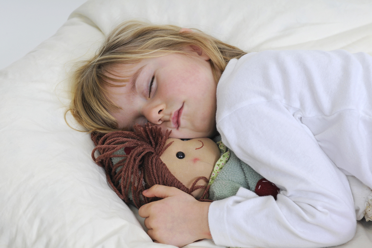 Kind schläft mit Kuscheltier