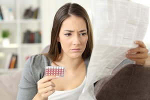 Antibiotika und Pille: Frau liest Beipackzettel