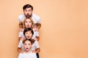Einfarbiger Hintergrund, gleicher Look und jetzt alle lächeln! Familienfotos im Fotostudio wirken oft gestellt.