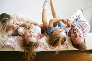 Das Bett ist der perfekte Spot für wunderschöne Familienfotos. Alle fühlen sich wohl und sind auf einer Ebene.