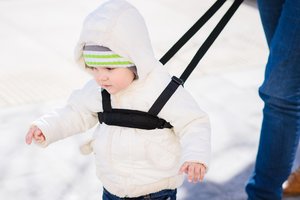 Kind hat eine Kinderleine um.