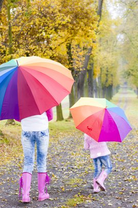 Mutter und Tochter unter bunten Regenschirmen