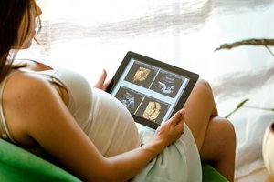 Werdende Mutter betrachtet Ultraschallbilder